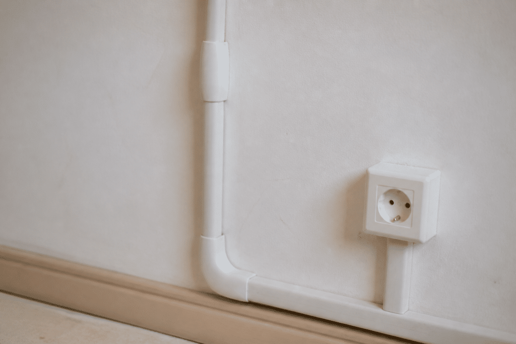 Fils electriques organises dans gaines blanches murales