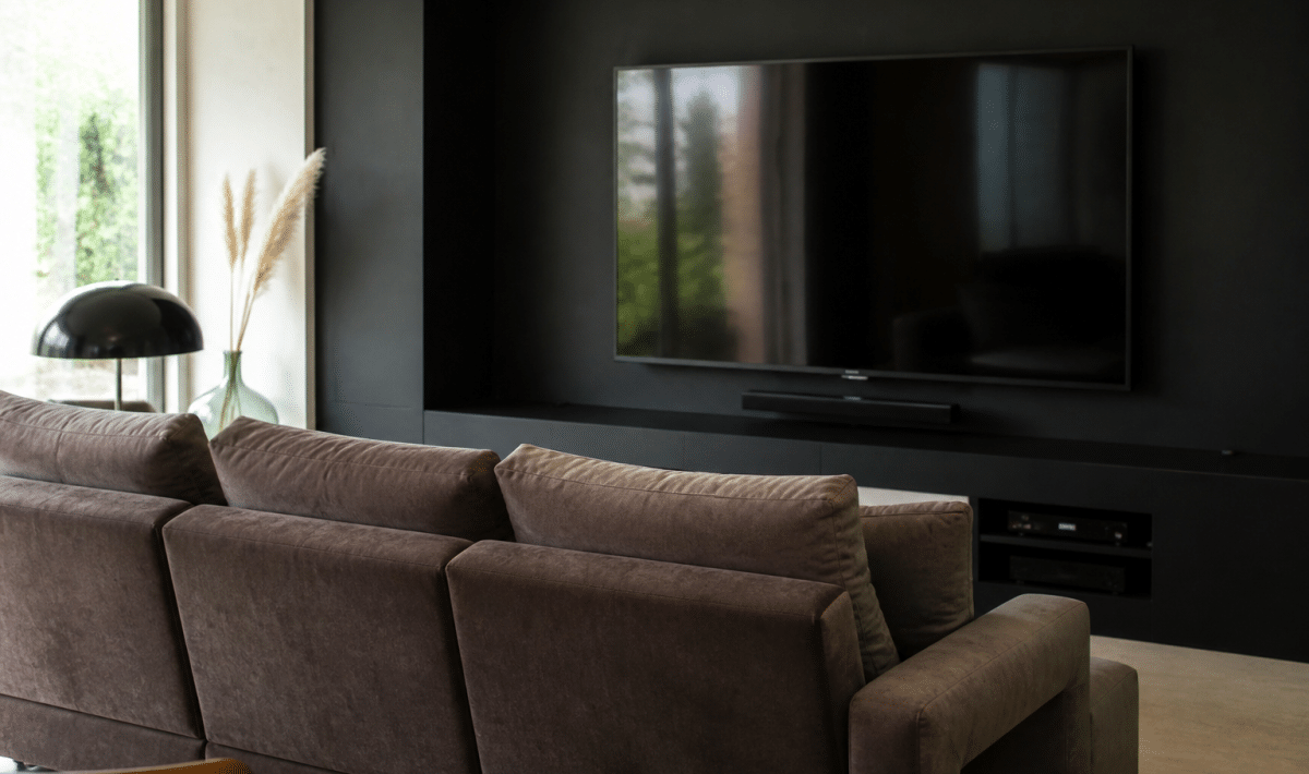 Canape rembourre face grand ecran mural noir