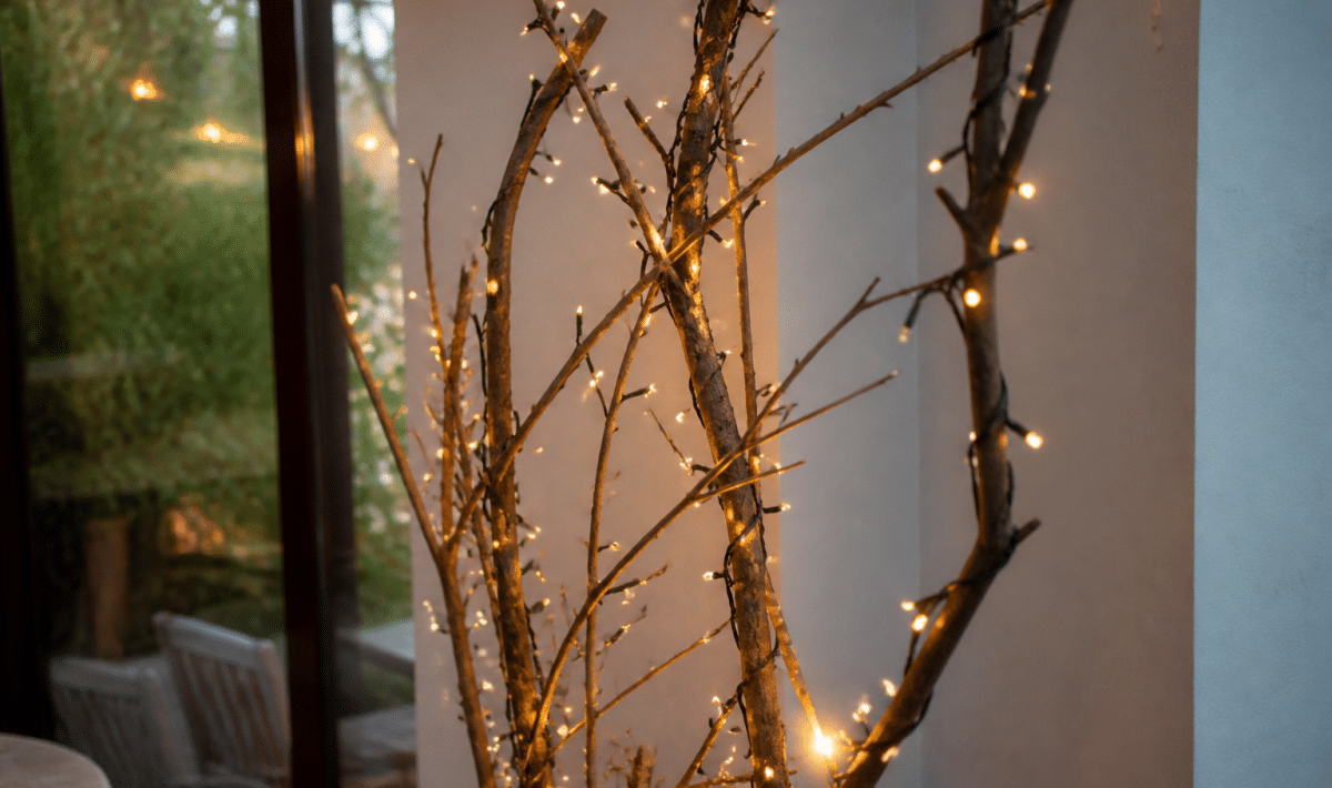 Guirlandes lumineuses enroulees autour de branches seches posees verticalement