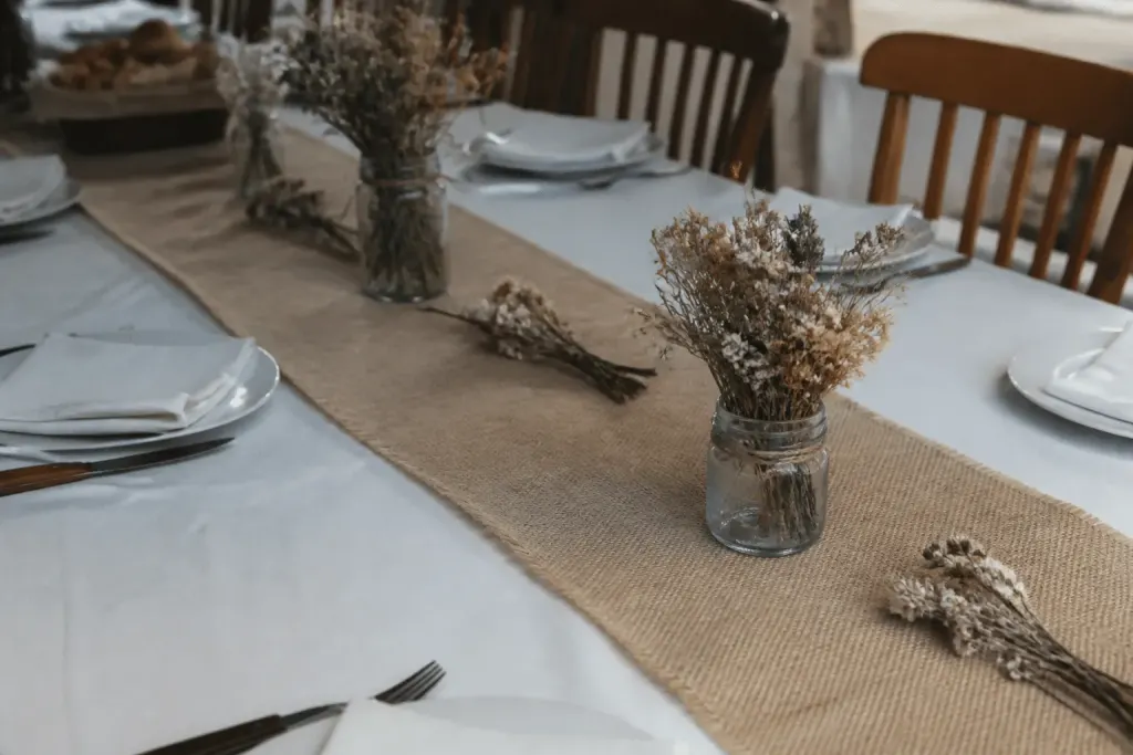 Nappe blanche avec chemin de table jute et fleurs séchées