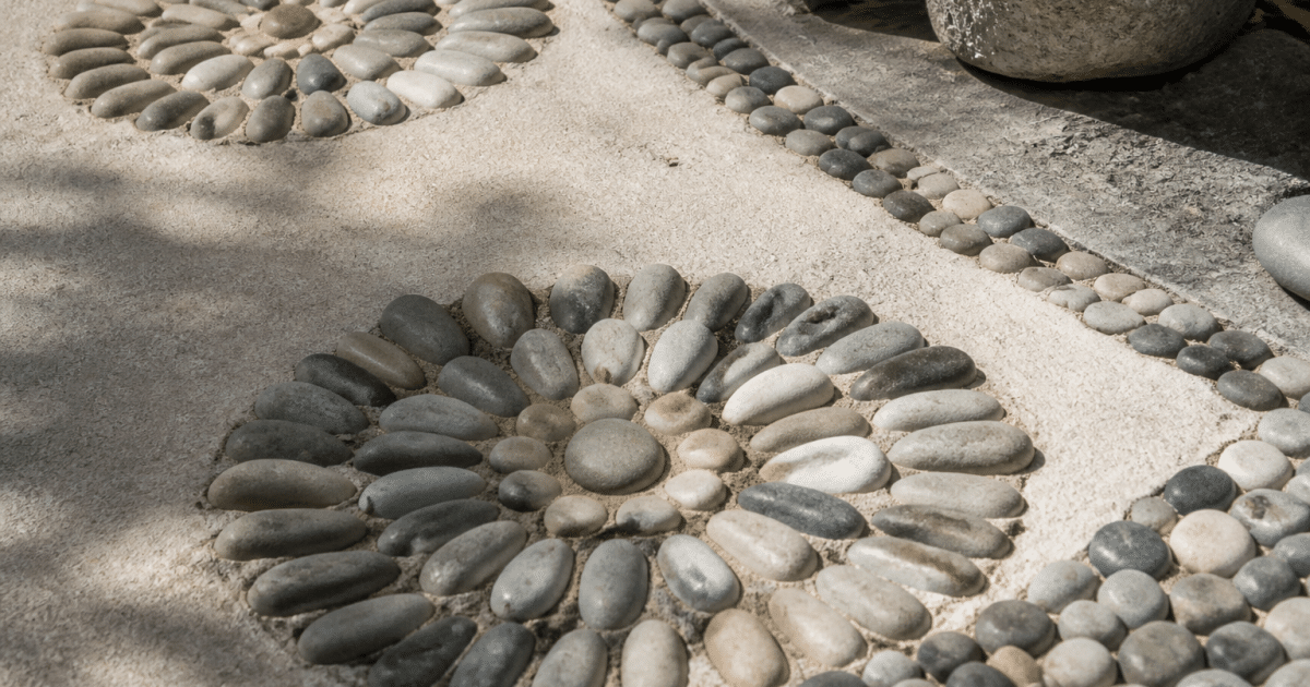 Pierres lisses disposees en motifs sur sol terrasse zen