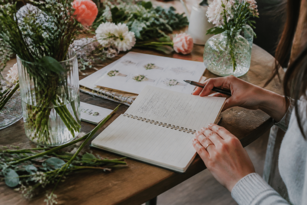 Carnet de planification avec fleurs, vases et liste de tables