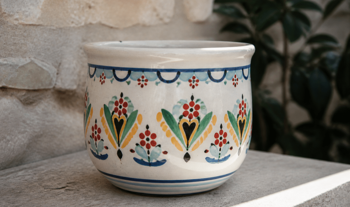 Pot ceramique blanc peint de motifs colorés posé sur surface