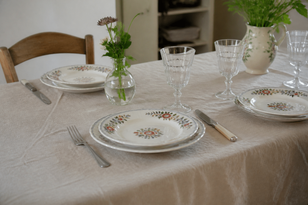 Table dressée avec lin naturel, assiettes fleuries coordonnées