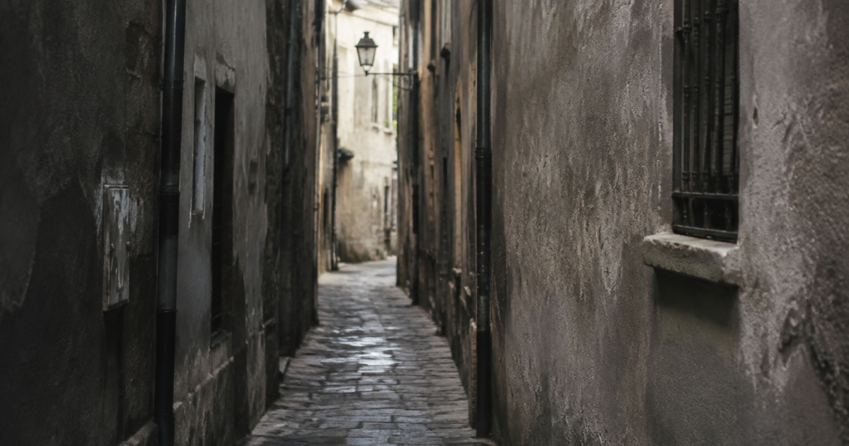 Rue etroite aux murs gris degrades et sombres