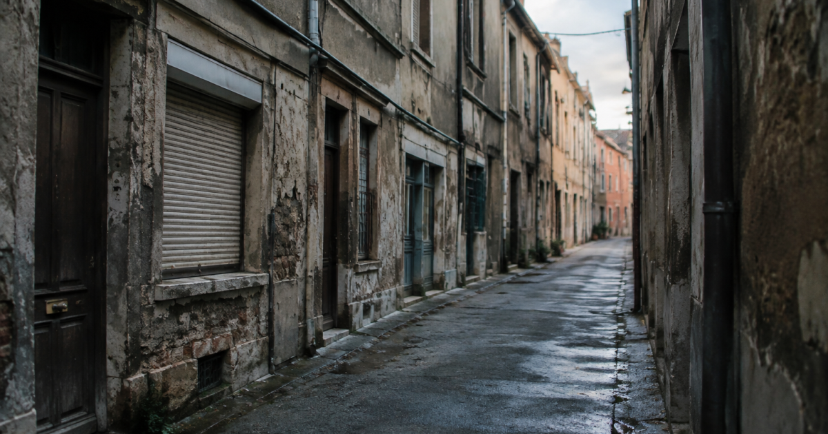 Rue sombre bordee d'immeubles decrepits et facades usees