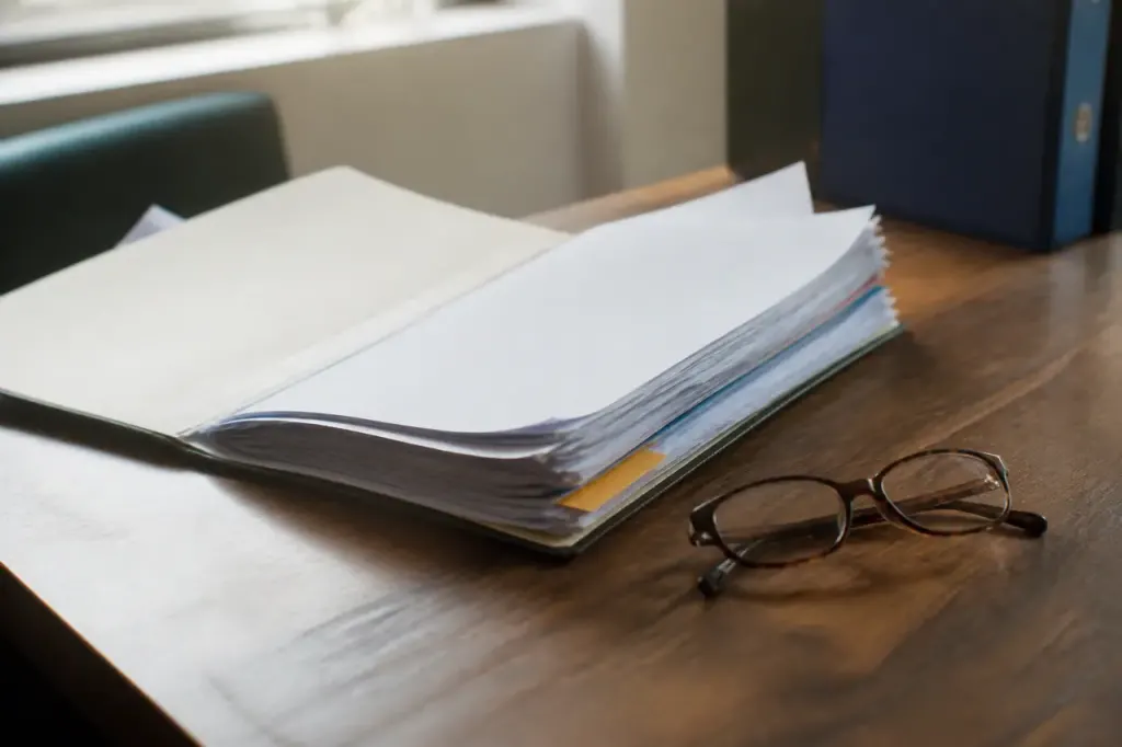 Dossier papier ouvert sur bureau avec lunettes