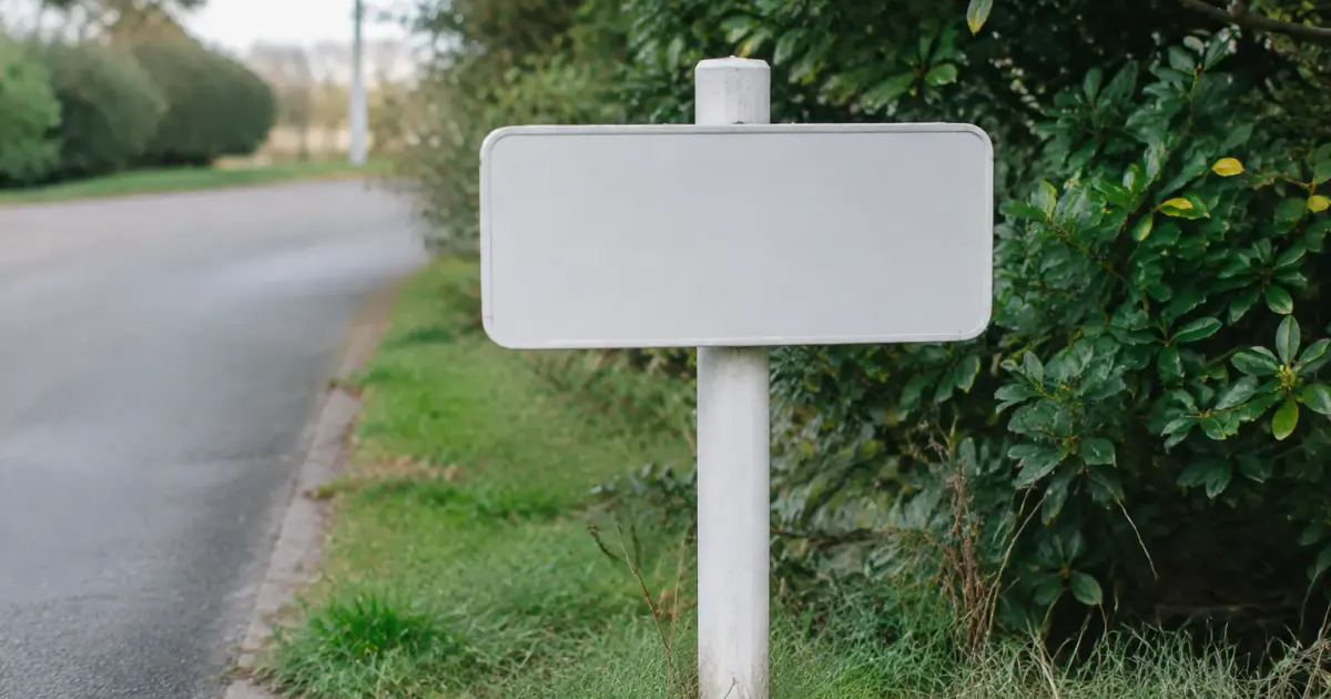 Panneau d'entree blanc plante au bord d'une rue