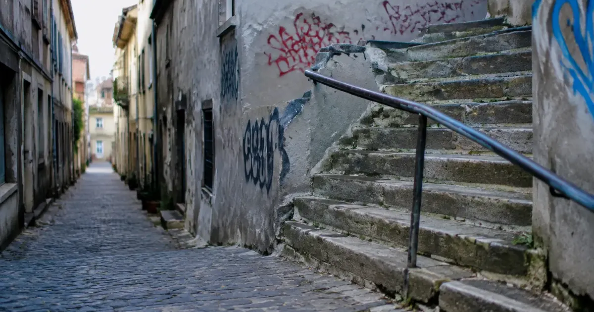 Rue pavee murs gris degrades graffitis escalier beton deteriore