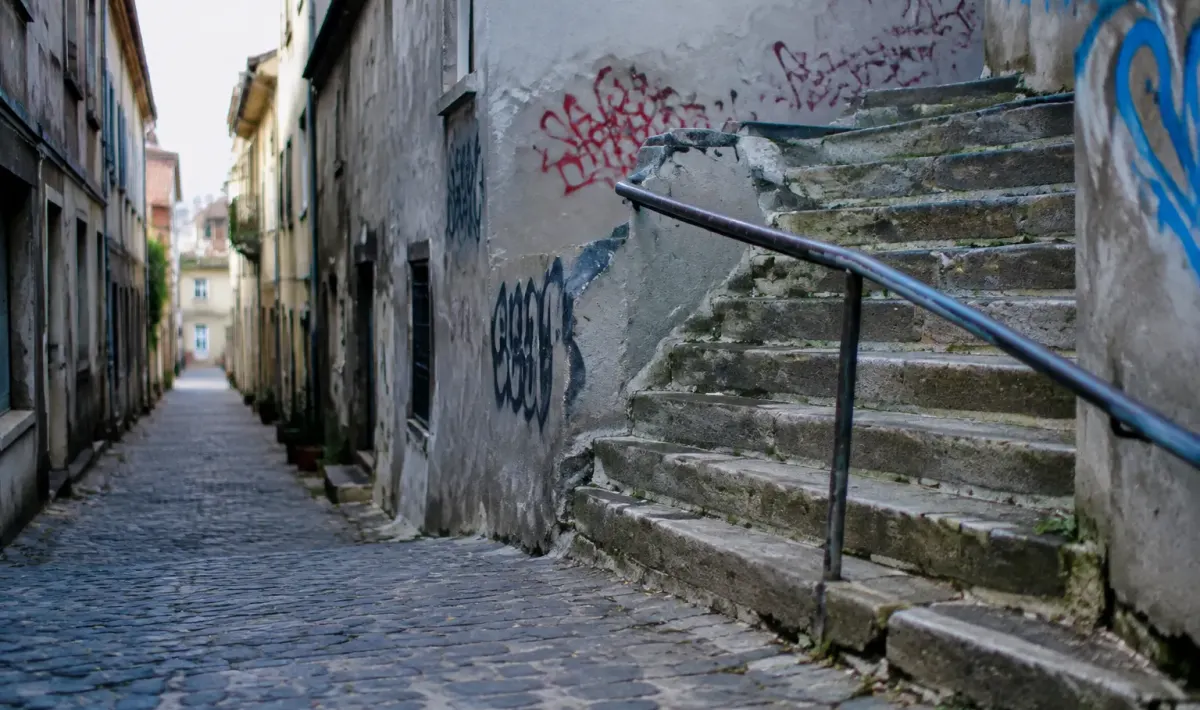 Rue pavee murs gris degrades graffitis escalier beton deteriore