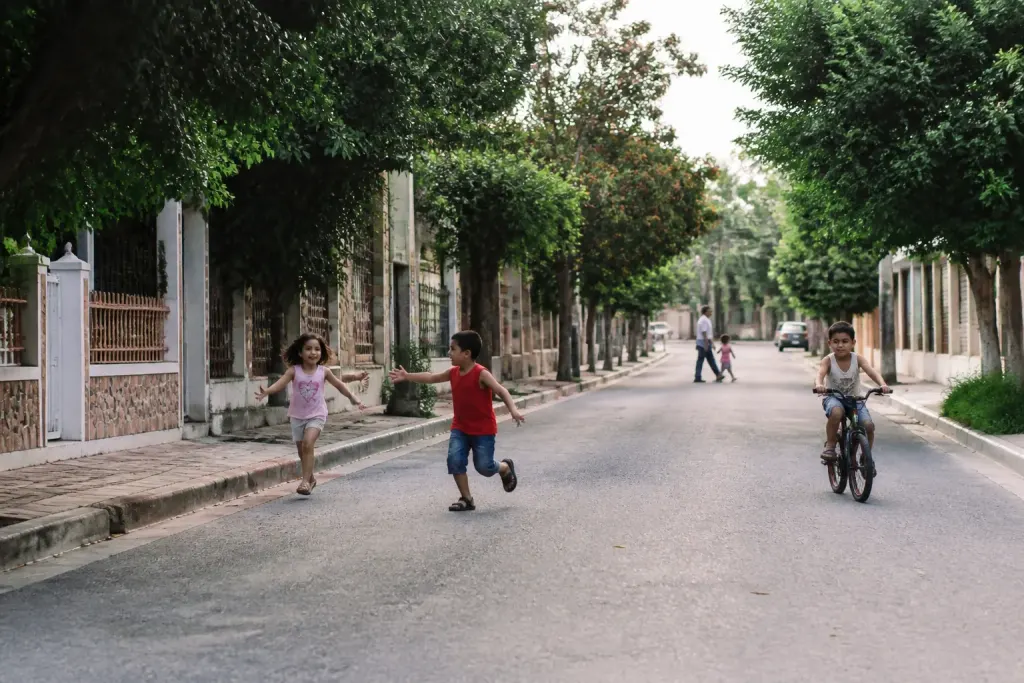 Rue residentielle avec ecoles commerces et enfants jouant