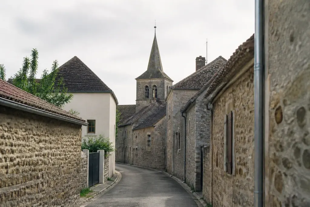 Rue de village avec clocher et maisons en pierre